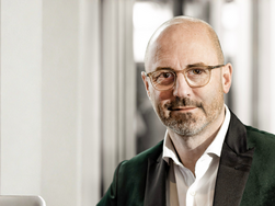 Dr. Timo Specht Chefarzt der Rehabilitationsklinik für Psychosomatik im AMEOS Reha Klinikum Ratzeburg blickt direkt und freundlich in die Kamera(© AMEOS). 