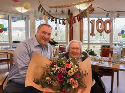 Bürgermeister Eckhard Graf überreicht Heide Manthey einen frühlingshaften Geburtstagsstrauß. (© AMEOS)